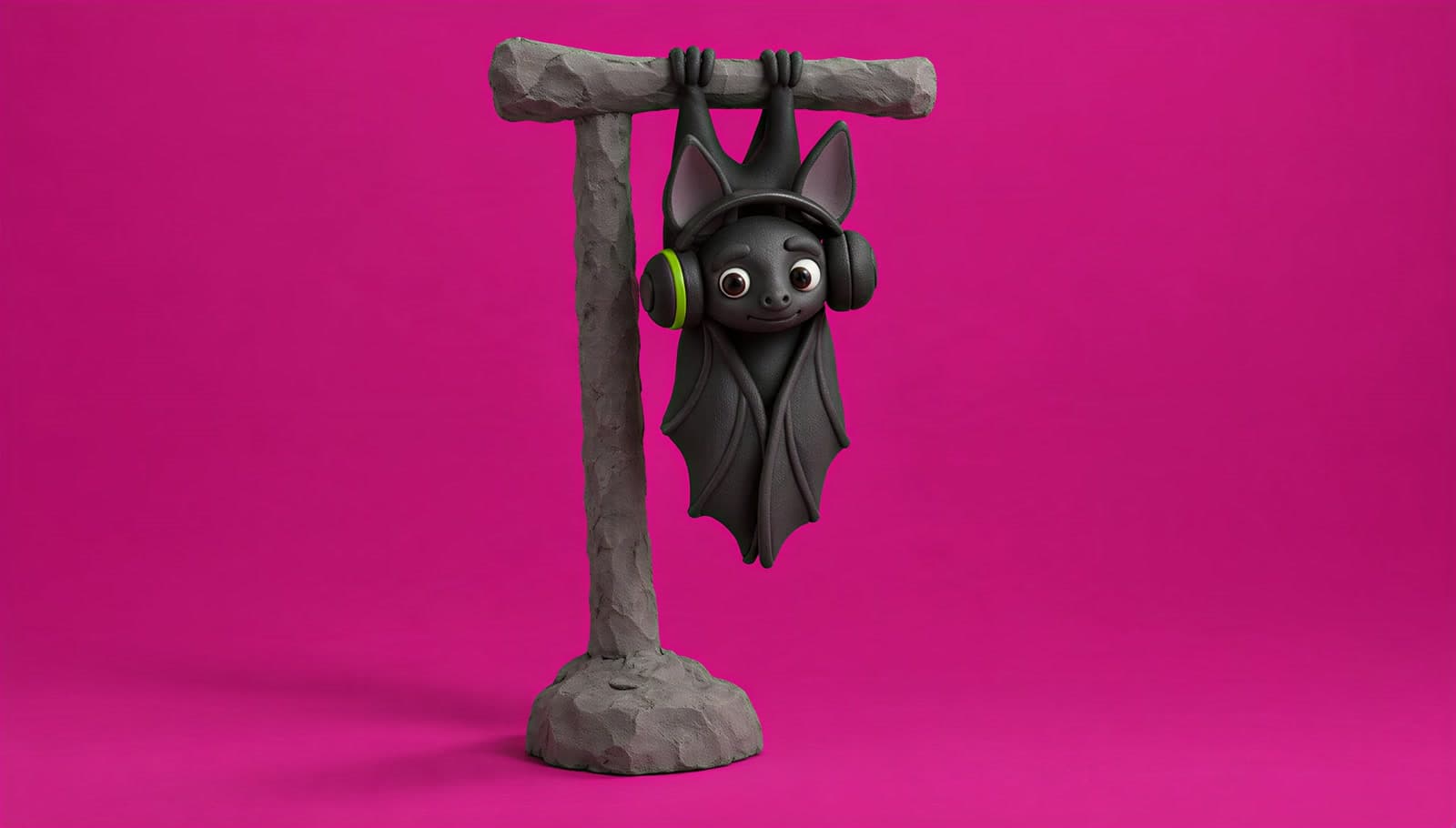 A clay bat in big near black headphones with a lime ring on one ear cup, hanging upside down from a grey clay perch on a magenta backdrop