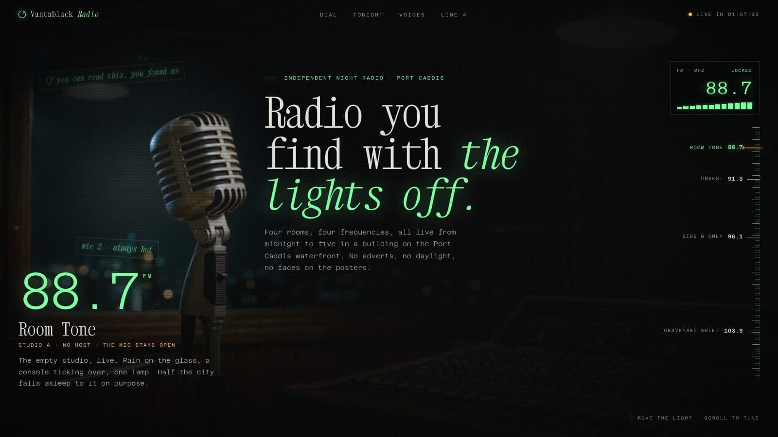 A vintage studio microphone lit in near darkness with a green frequency readout and dial