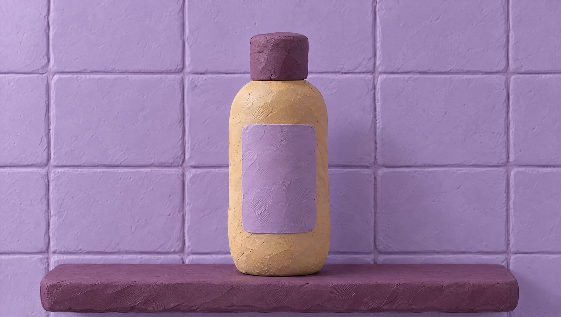A biscuit clay bottle of dry shampoo with a plum cap on a plum shelf