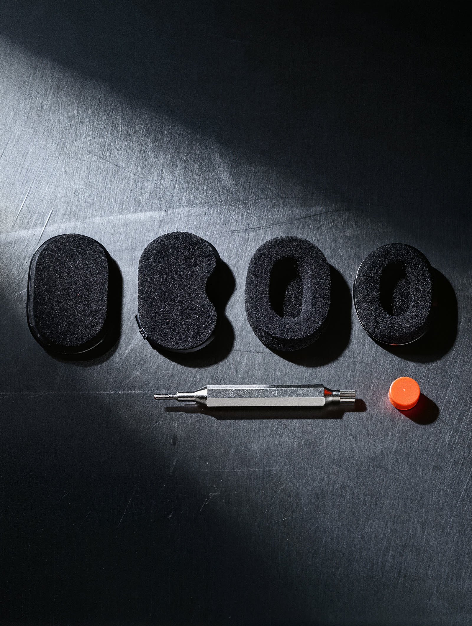 Replacement ear pads and hex tool laid out in a row