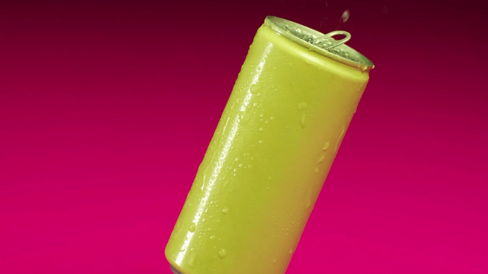 A pistachio can tilted on a gradient from deep plum to hot pink, droplets running down its side